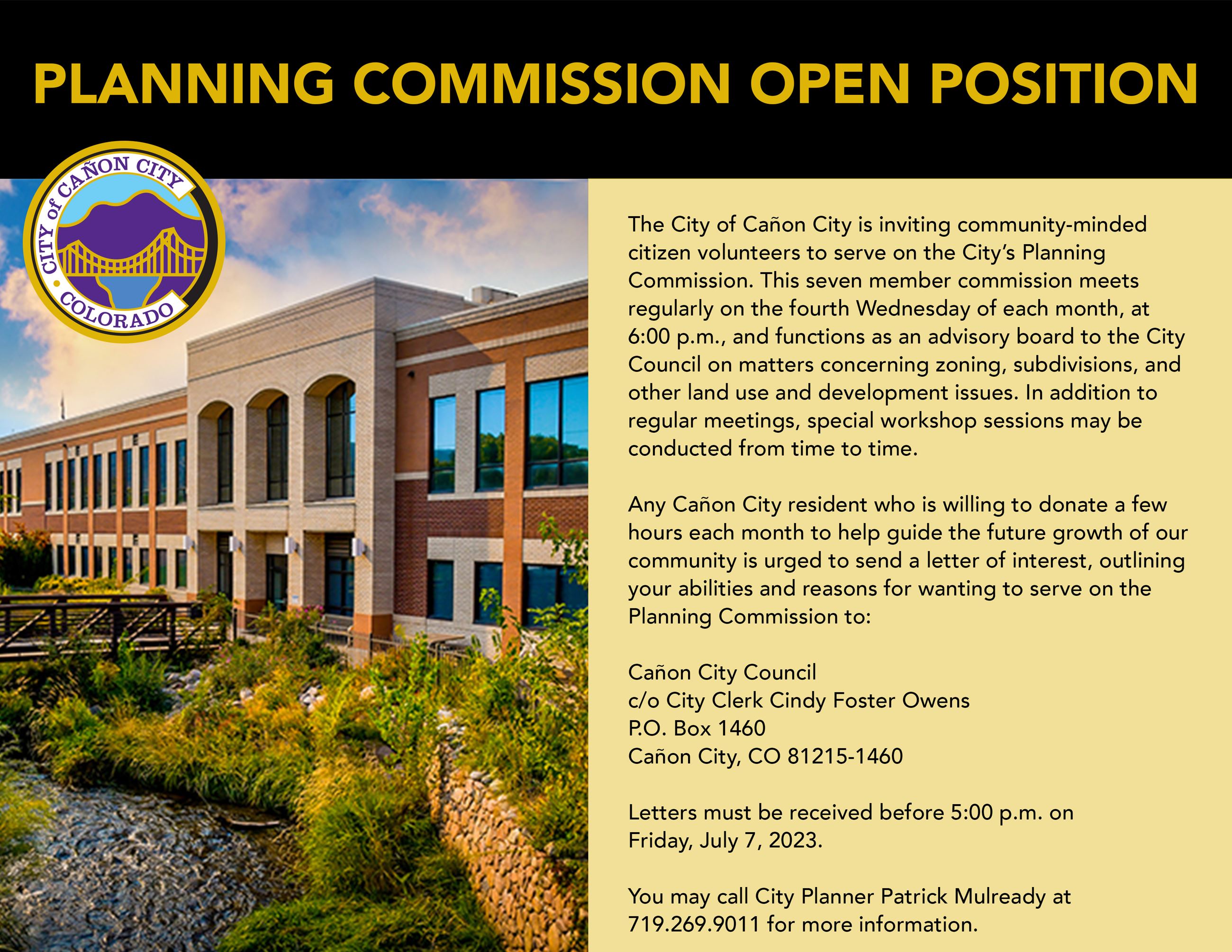 Photo of back of City Hall Building with a metal brown bridge and hydraulic ditch in the foreground.