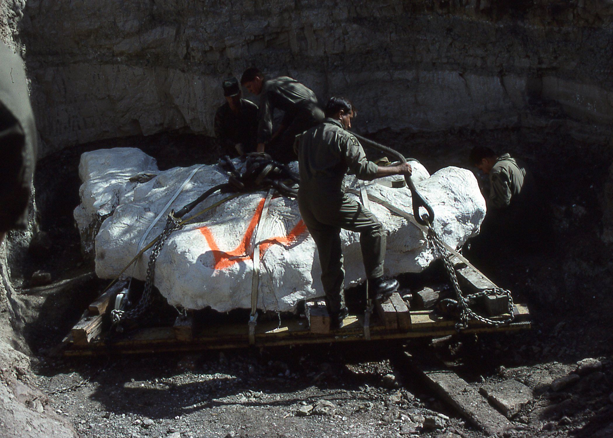 Color photo of the US Army members preparing the harness to lift the stegosaurus fossil. Circa 1992.